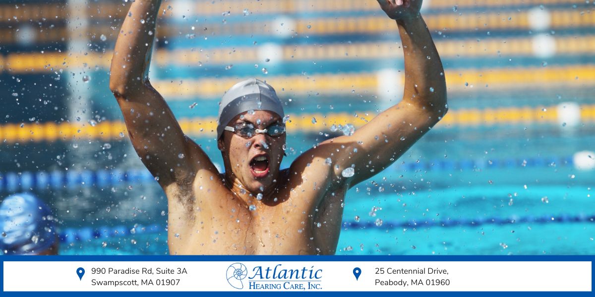 Swimmer celebrating in a pool, representing swim earplugs for ringing ears